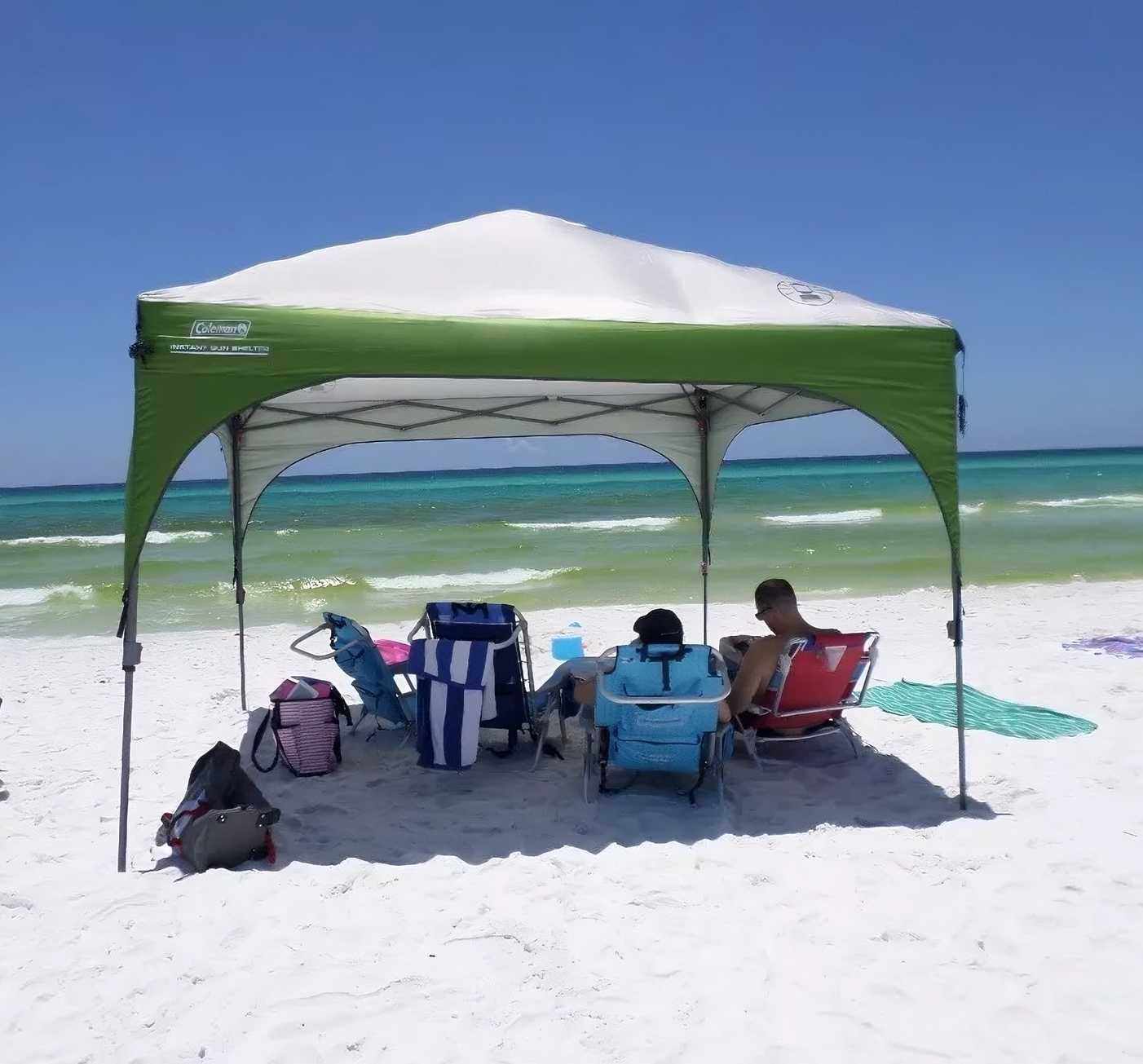 blue sky, the beach boasts the best beach shade—a remarkable green and white tent known as the Coleman Instant Eaved Shelter.