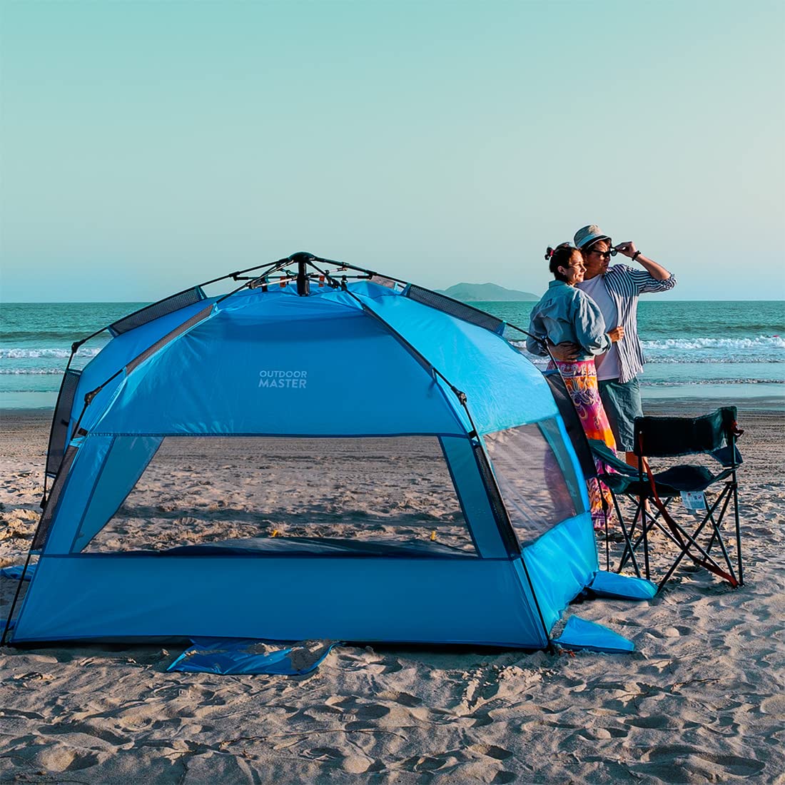 blue pop up breach Tent with couple standing with his kid evening time