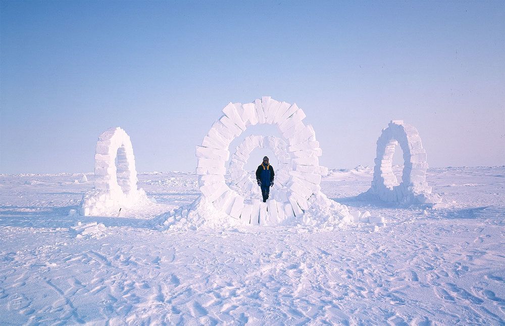 Four large ice sculptures created by Andy Goldsworthy at the North Pole. The sculptures are made entirely of ice and display intricate and delicate patterns. The sculptures stand tall against the icy backdrop of the Arctic landscape, showcasing the artist's masterful craftsmanship and the ephemeral nature of his work