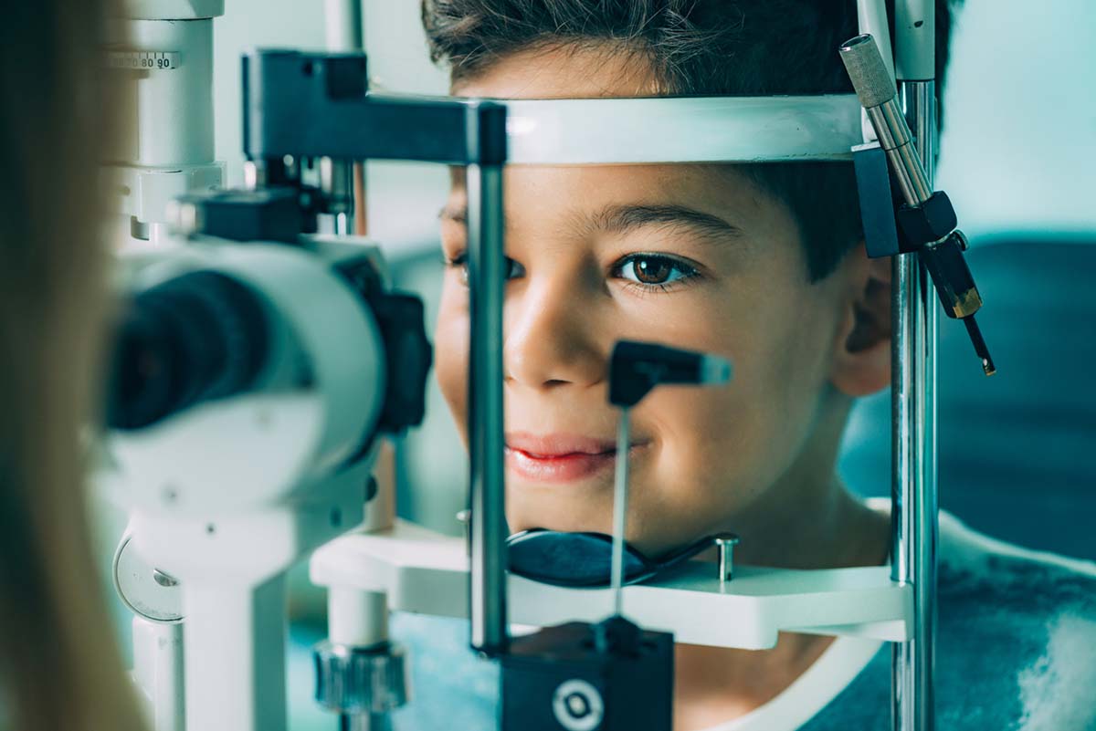 Eye Exam. Ophthalmology, slit lamp exam, school boy having his eye sight checked