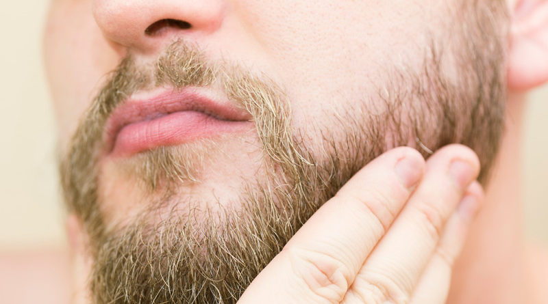 Brushing beard with hand after trimming