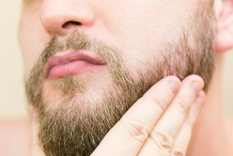 Brushing beard with hand after trimming