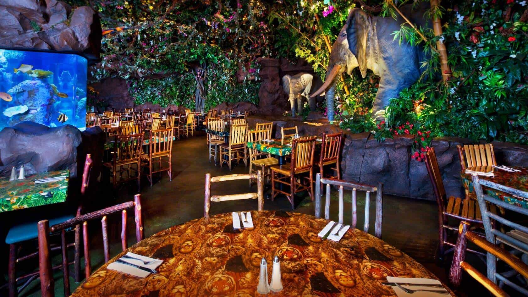 Rainforest cafe theme with Animals and Artificial plants all around the wooden table 