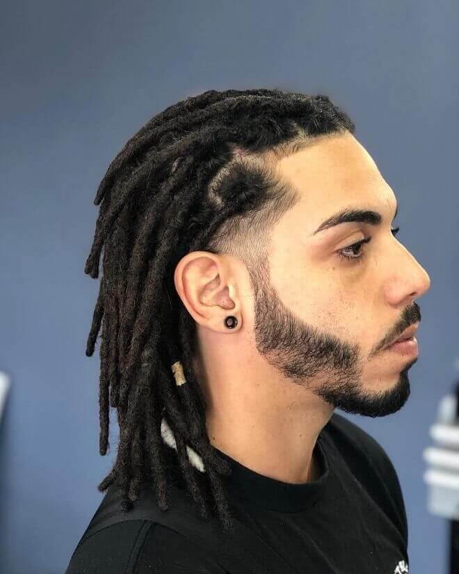 a man face zoomed with Back dreadlock combined and a black shirt.