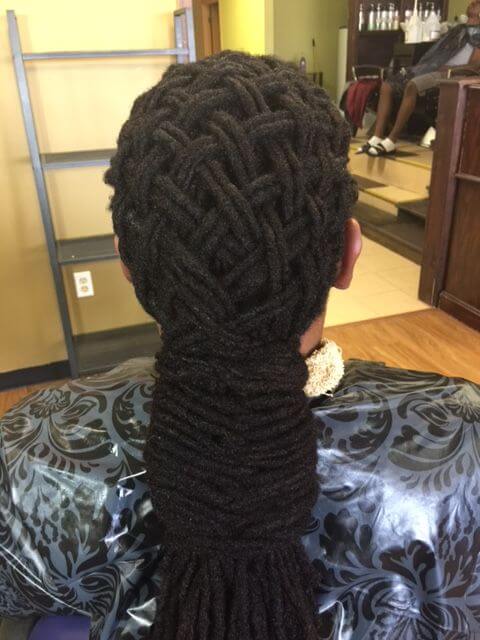 A man with a Basket Weave Dreadlocks braid hairstyle sitting in a chair showing his hair only.