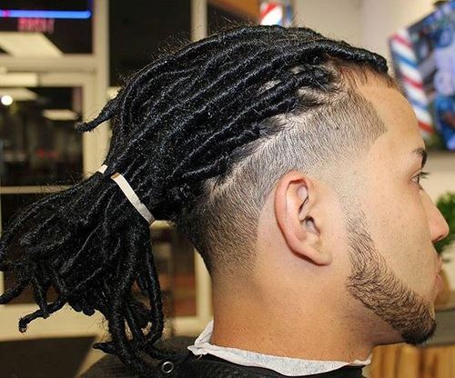 A man with faded dreads style in a barber shop.
