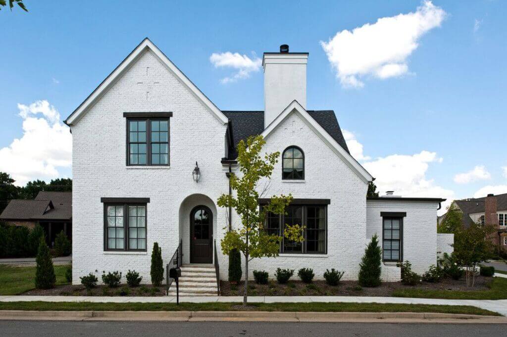 Small Black roof And trim white house with black Door