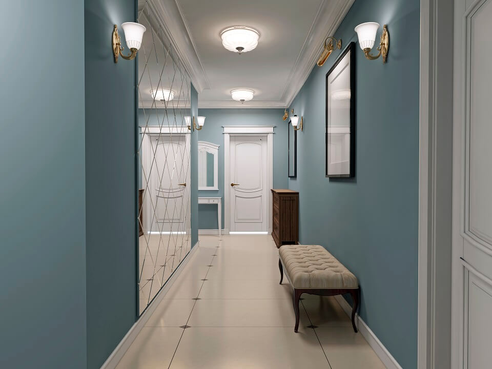 hallway is classic style with light blue walls light ceiling with white doors