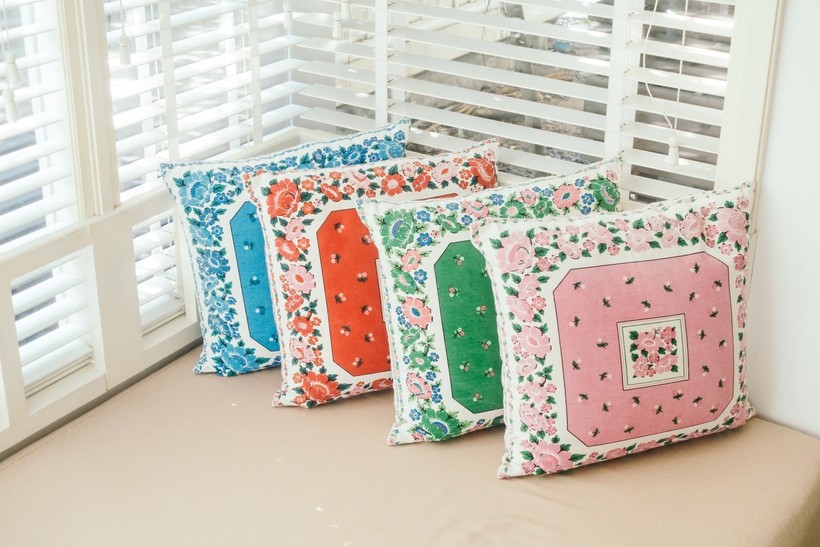 Colorful handcrafted pillow cover on table showing DIY home décor