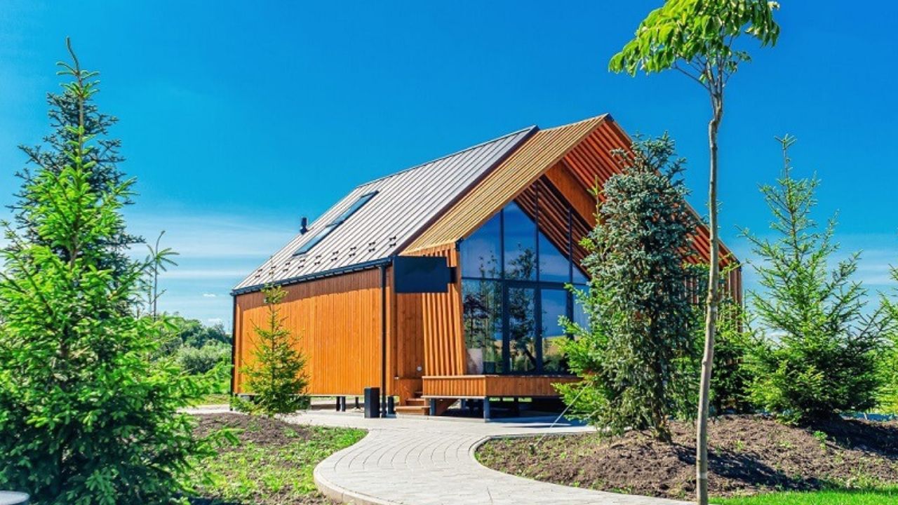 Small A Rooftop Container house with windows and Door of glass on one side and clear Pathway in front with gadder nearby