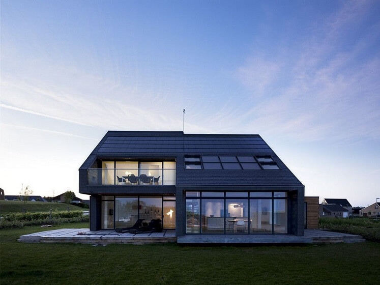 Black 2 Story Sustainable House Design front side with Big sliding Windows and Balcony on second floor also Solar on Roof