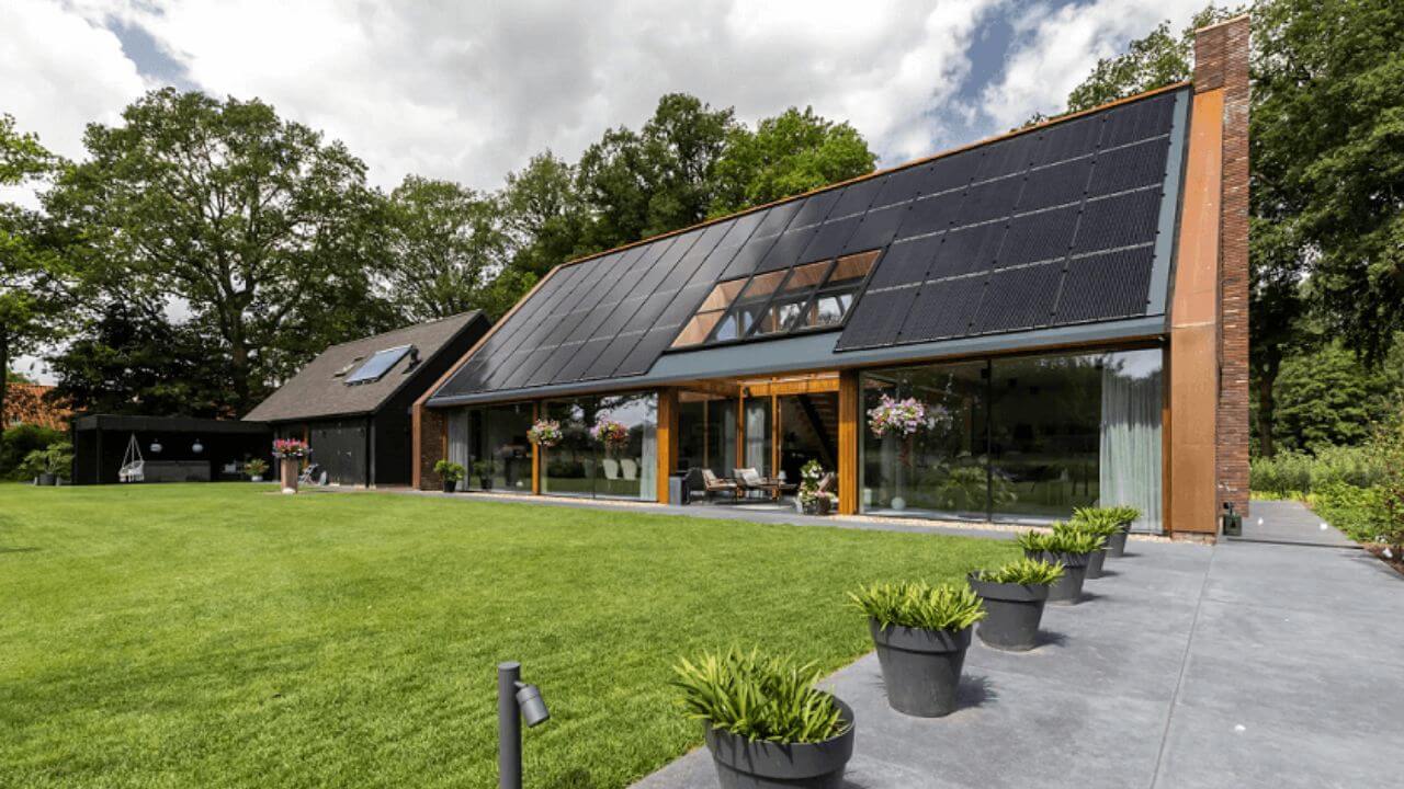 Wide sustainable House rooftop full of Solar Panel and Big Windows and a Yard and walkway in front