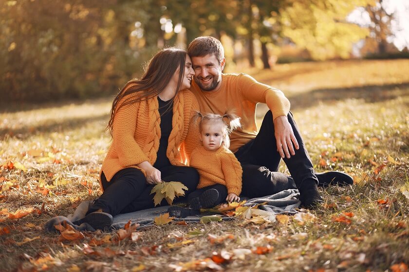 Family wearing autum outfir sitting on blanket