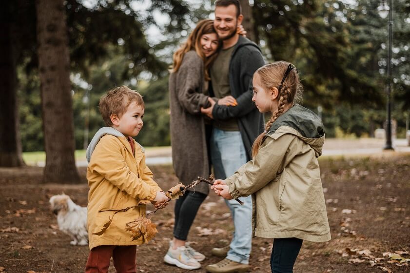 Happy Parents watching Childen Playing in Park