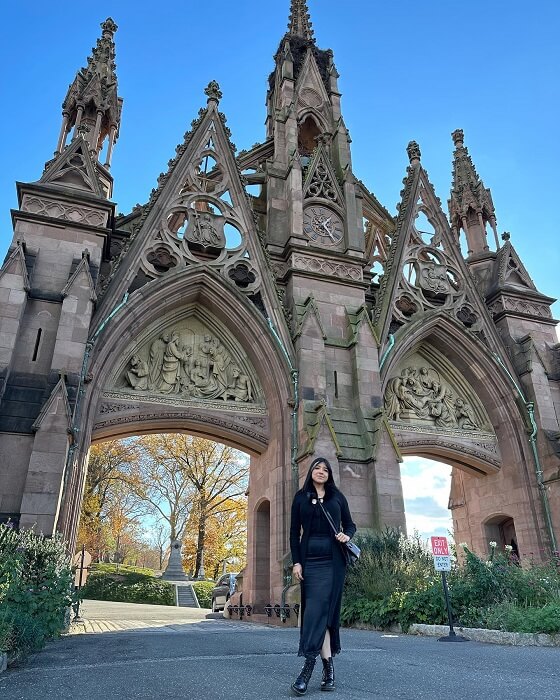Women Wearing Black Pose Near Gate of The Green Wood Cemetery For Instagram