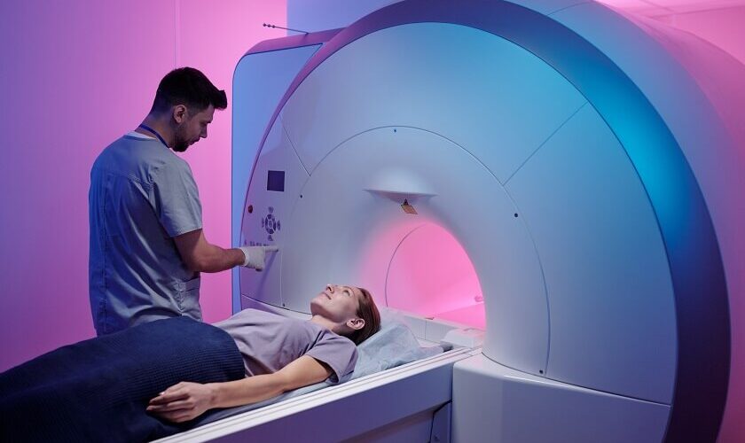 young doctor pushing button panel start mri scan procedure