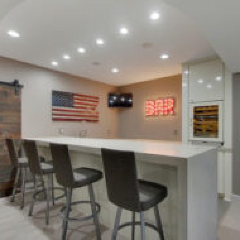 The white and grey blend of the American basement bar transforms it into a men's cave,